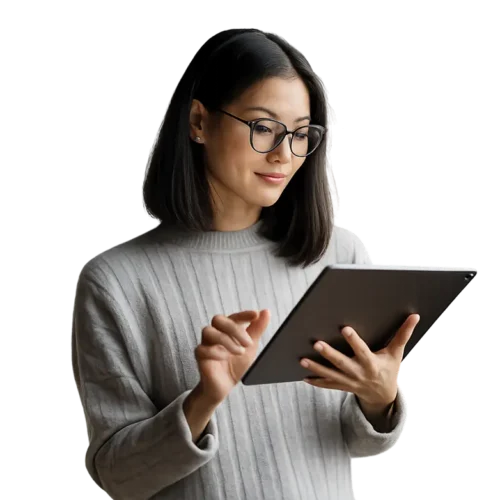 Woman with glasses using a tablet, wearing a gray sweater.